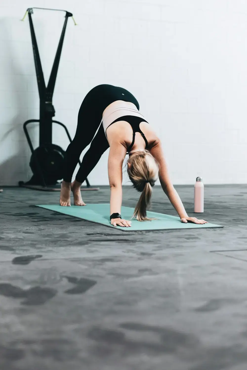 Client stretching through a downward dog on a yoga mat at home