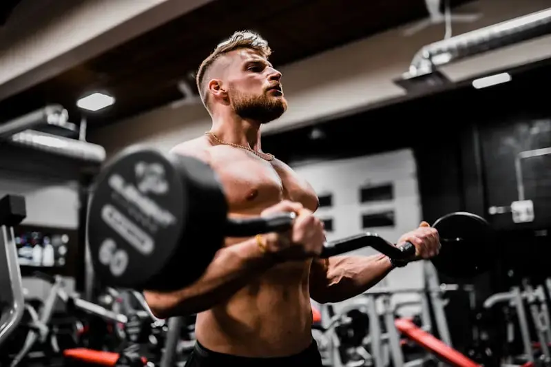 Trainer performing a barbell curl in a home gym