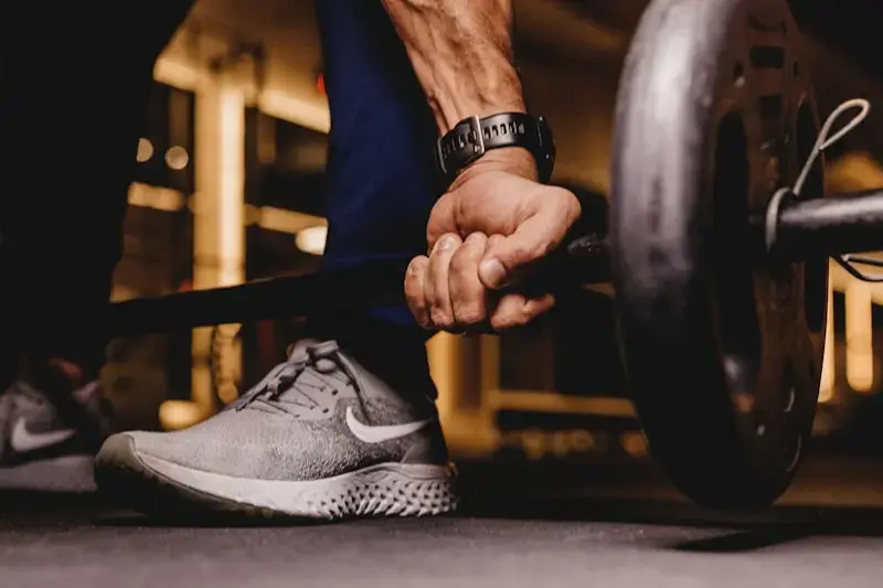 Close-up of a hand gripping a barbell mid-lift